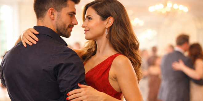 casal dançando com postura confiante em salão iluminado